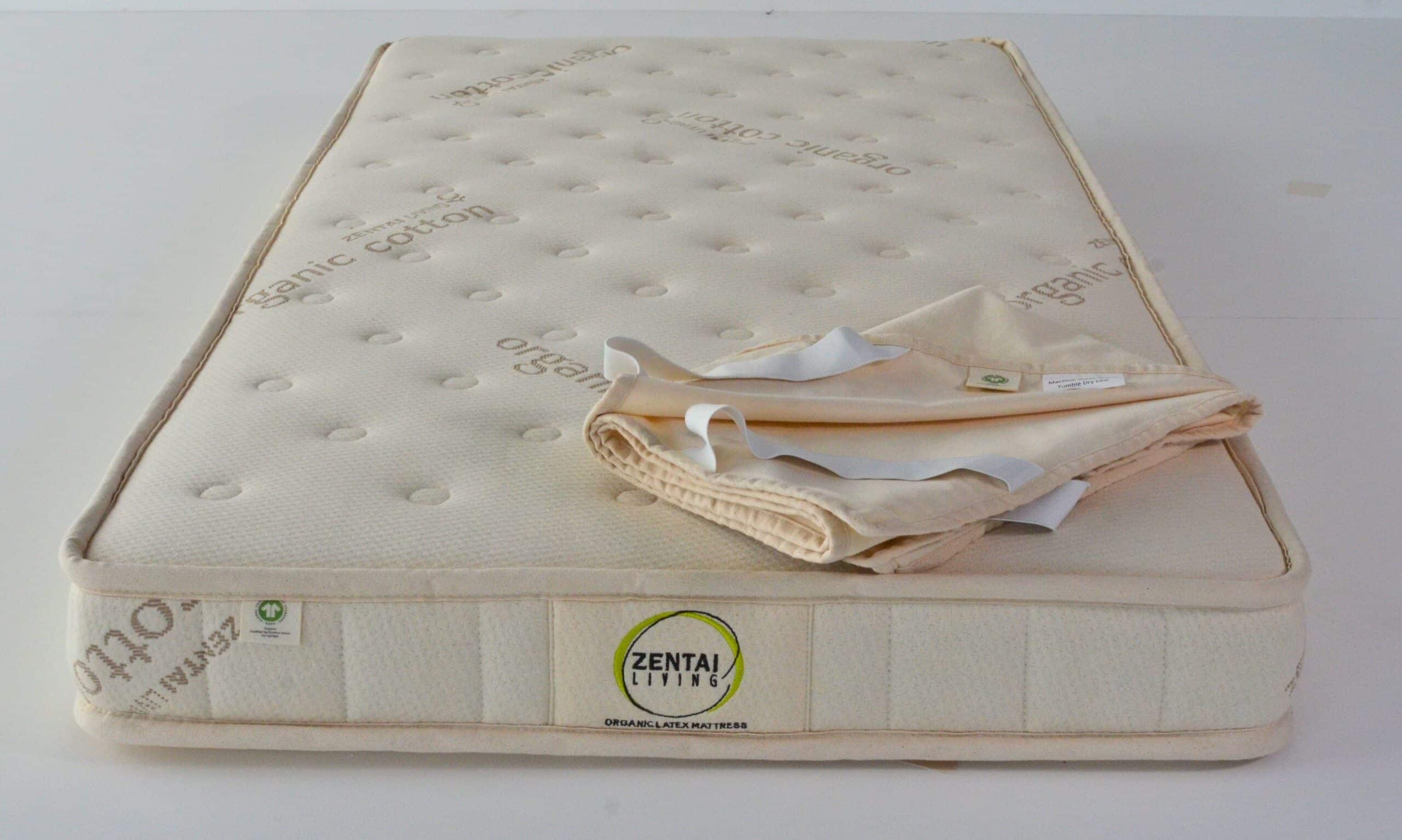 Waterproof protector being fitted to the cot mattress, sold separately